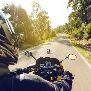 Motorcycle speeding down on an empty country road from over rider"u2019s point of view. Focus is on the motorbike with road motion blurred